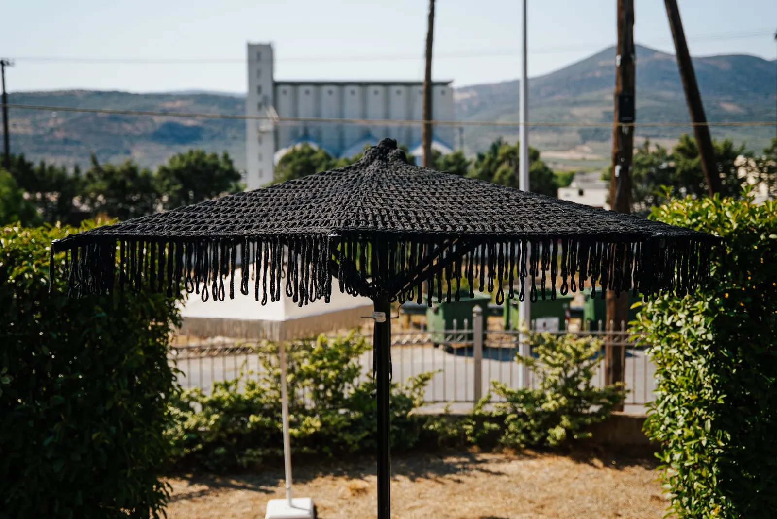 Μαύρη ομπρέλα Metal Design με κρόσσια στον κήπο της Metal Design στον Βόλο